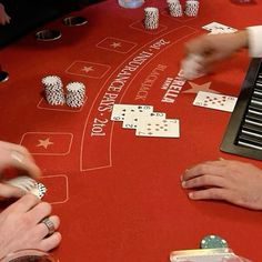 people playing cards at a casino table with their hands in the air and chips on top