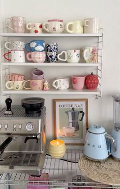 the shelves are filled with coffee cups and tea kettles, including an espresso machine