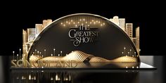 the greatest show logo on display in front of a cityscape with buildings and lights