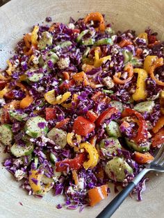 a salad with red cabbage, carrots, and other veggies in a bowl