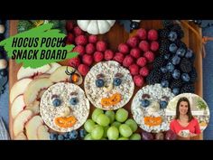 a wooden tray topped with fruit and veggies next to a smiling face made out of crackers