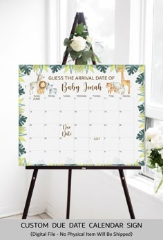 a baby shower calendar with flowers and greenery on the side, in front of a window