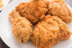 three fried chicken patties on a white plate