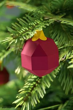 a red ornament hanging from a christmas tree