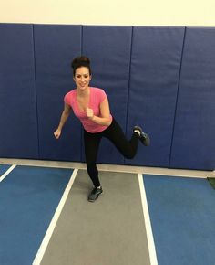 a woman in pink shirt and black pants doing exercises