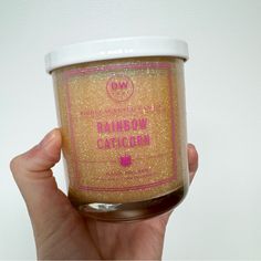 a hand holding up a jar of brown colored cake mix with pink writing on it