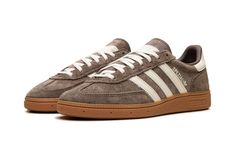 The Women’s adidas Handball Spezial “Earth Strada/Gum” is a women’s-exclusive colorway of the lifestyle shoe with an earth tone color scheme.  The upper is complete with an Earth Strada, or brown, suede construction and contrasted with Cream leather Three Stripes branding on the sides.  Cream “Spezial” and adidas Trefoil logos appear on the lateral side of the mid-panel, while more cream leather can be found on the heel tab.  Underfoot, a gum sole completes the look.  Release date: November 10, 2023 Jordan Dunk Low, Gum Shoes, Mid Jordan 1, Low Jordan 1, Adidas Sl 72, All Jordans, Adidas Handball Spezial, Sneakers Box, Adidas Handball