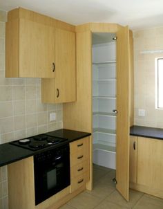 an empty kitchen with wooden cabinets and black counter tops