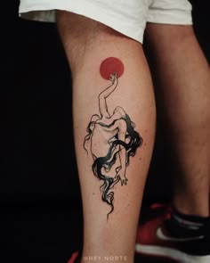 a tattoo on the leg of a person with a red sun in the sky behind her