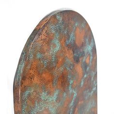 a metal object with blue and brown paint on it's surface, against a white background