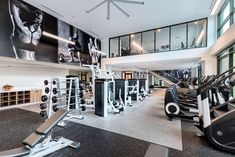 a large gym with treadmills, exercise machines and other personal equipment in it