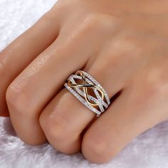 a woman's hand with a gold and white ring on top of her finger