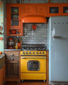 an old fashioned stove and refrigerator in a small kitchen with orange cupboards on the walls