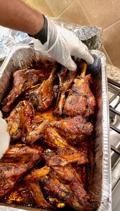 a person in white gloves is cleaning some meat