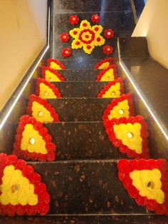 an escalator decorated with red, yellow and orange flowers on the bottom step