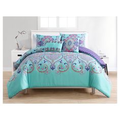 a bed with blue and purple comforters in a room