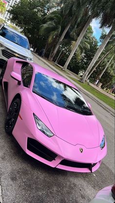 a pink sports car parked on the side of the road