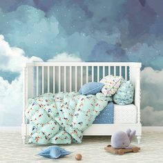 a child's room with a blue sky mural and white crib bedding