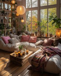 a living room filled with lots of furniture and large windows overlooking the trees in the forest