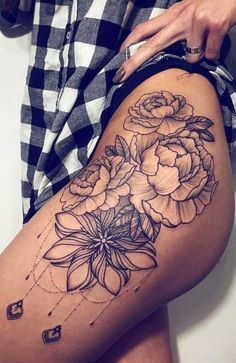 a woman is showing off her thigh with flowers on it and the bottom half of her leg