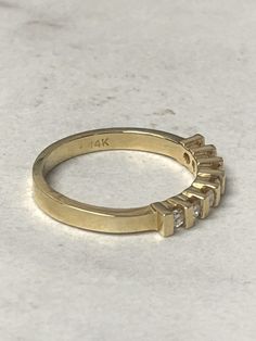 a yellow gold ring with five small diamonds