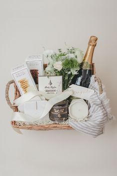 a wicker basket filled with champagne, candles and other items for a bridal party