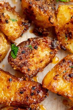 some fried food is sitting on a piece of parchment paper with parmesan cheese