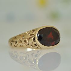 "14k gold ring with big oval red Garnet. Solid gold ring, a perfect Anniversary gift idea. The ring sides are decorated with delicate eastern-romantic ornaments and through them, you can see the red shade of the Garnet. The ring is 14k solid gold, completely handmade by me in a unique wax engraving technique, * The ring in 14k solid gold * Garnet 8 * 10 m\"m Back to my shop: https://www.etsy.com/il-en/shop/malkaravinajewelry?ref=seller-platform-mcnav More Gemstone rings: https://www.etsy.com/il- Oval Engraved Ring With Gemstone In 14k Gold, 14k Gold Oval Engraved Ring With Gemstone, Formal Oval Engraved Ring With Gemstone, Formal Oval Gemstone Engraved Ring, Oval Gemstone Engraved Ring For Formal Occasions, Oval Ruby Ring In 14k Gold As Gift, Elegant Red Signet Ring For Wedding, Gold Garnet Signet Ring For Anniversary, Elegant Red 14k Gold Signet Ring