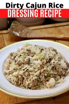 a white plate topped with rice covered in ground beef and green onions on top of a wooden table