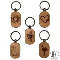 six wooden key chains with different designs and symbols on them, each featuring a bee