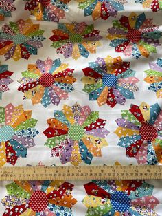 a close up view of a quilted fabric with flowers and dots on white background