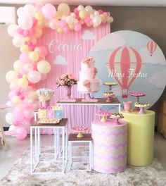 a pink and yellow dessert table with balloons