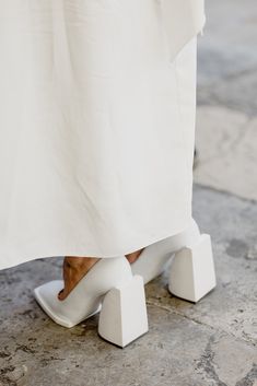 a woman's feet in white shoes on the ground