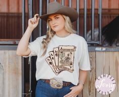 This Comfort Colors western t-shirt featuring a skeleton cowboy is perfect for a country rodeo. The "Ain't Going Down" shirt, desert shirt, and Texas t-shirt make a great gift for any cowgirl. 🌺 D E T A I L S → Comfort Colors garment-dyed t-shirt  → 100% ring-spun cotton → Medium fabric (6.1 oz/yd² (206.8 g/m → Relaxed fit → Sewn-in twill label 🌺 H O W - T O - O R D E R 1.  Please select variants from drop down menu 2. If you are buying multiple items, add each item to your cart separately and White Western T-shirt For Rodeo, White Short Sleeve Tops For Country Events, Country Style Short Sleeve T-shirt For Ranch, Graphic Tee For Country Events With Short Sleeves, Western White T-shirt For Country Events, Country Style Short Sleeve T-shirt For Rodeo, Short Sleeve Graphic Tee For Country Events, Western Style White T-shirt For Country Events, Western Crew Neck Tops For Country Events