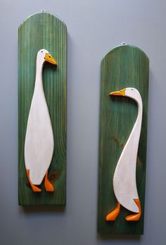 two white and orange ducks on wooden boards