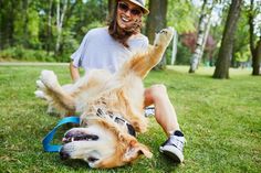 a man is playing with his dog in the park