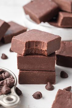 chocolate fudges stacked on top of each other next to a bowl of chocolate chips