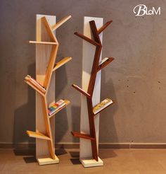 two wooden bookshelves are standing next to each other in front of a wall