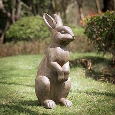 a statue of a rabbit sitting in the grass