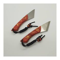 three knives are wrapped in black cord and have orange designs on the handles with gold dots