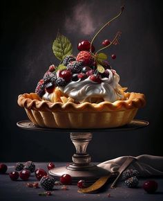 a pie topped with berries and whipped cream on top of a metal cake platter