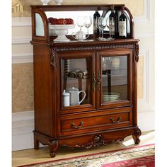 a wooden cabinet with glass doors and wine glasses on the top shelf in front of it