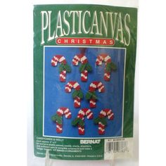 plastic canvas christmas decorations with candy canes on the front and green packaging behind them