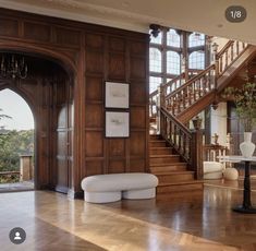 a living room with wood paneling and stairs