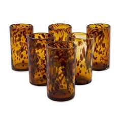 four brown glass tumblers sitting next to each other