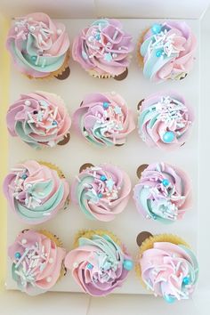 cupcakes with pink, blue and white frosting in a box