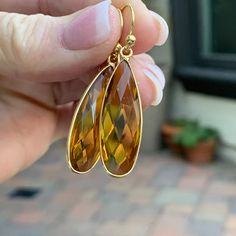 These beautiful citrine earrings are faceted and teardrop shaped in a gold plated bezel setting. The ear wires are also gold plated. Total length: 1.75 inches Citrine teardrop with bezel alone: 34 x 11 x 6mm To see more from East Village Jewelry~ http://eastvillagejewelry.etsy.com All orders ship out within 24 hours, excluding holidays and Sundays Feel free to contact me with any questions. Use coupon code VILLAGE14 for 10% off all orders over $200.00 THIS ITEM WILL SHIP OUT WITHIN 24 HOURS OF O Gold Teardrop Earrings With Gemstone For Anniversary, Gold Teardrop Gemstone Earrings, Gold Gemstone Teardrop Earrings For Formal Occasions, Gold Teardrop Earrings For Anniversary, Gold Citrine Drop Jewelry, Gold Nickel-free Teardrop Earrings For Anniversary, Gold Drop Earrings With Faceted Details, Pear-shaped Citrine Gold Jewelry, Citrine Teardrop Earrings For Gift