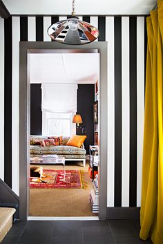 an open door leading to a living room with black and white striped walls