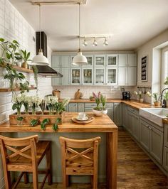 a kitchen filled with lots of counter top space and wooden chairs next to a sink