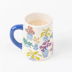 a blue and white coffee mug with flowers on the inside is holding a tea candle